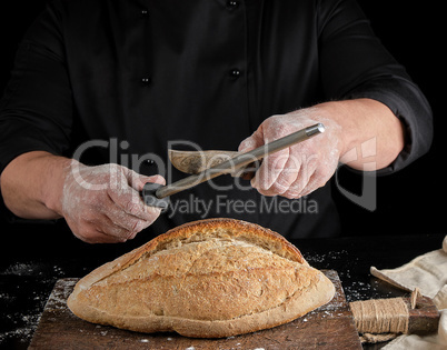 chef in black uniform sharpens a kitchen knife