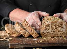 sliced rye bread with pumpkin seeds on a brown wooden board