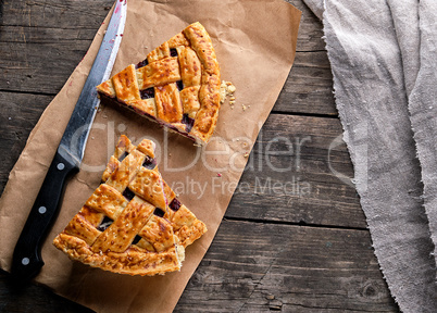 baked cakes with a cherry and a kitchen knife are on brown paper