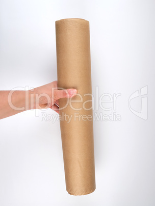 hand hold a large roll of brown parchment paper