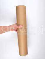 hand hold a large roll of brown parchment paper