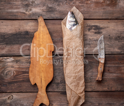 Fresh whole sea bass fish wrapped in a brown paper  and tied wit