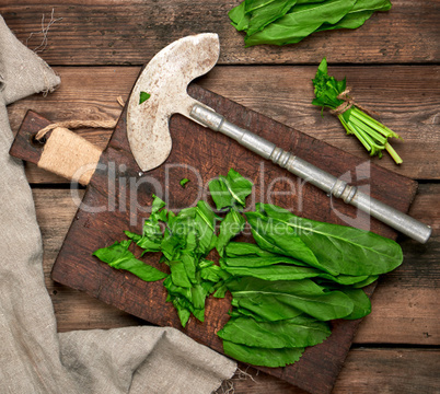 bunch of fresh green sorrel leaves and old brown cutting board