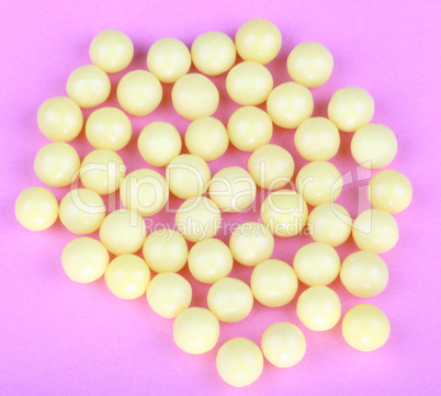 yellow vitamins on pink background