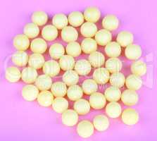 yellow vitamins on pink background