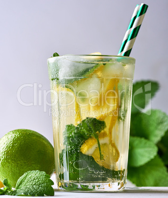 refreshing drink lemonade with lemons, mint leaves, lime in a g