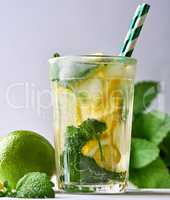 refreshing drink lemonade with lemons, mint leaves, lime in a g