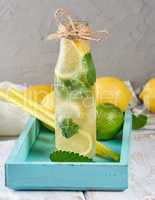 cold drink with lemons, mint leaves, lime in a glass bottle