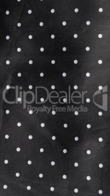 black fabric background with white dots