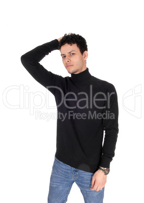 Young man in a black sweater and jeans one hand on head