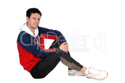 Happy young man sitting on the floor resting from exercise