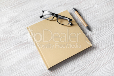 Square book, glasses, pen