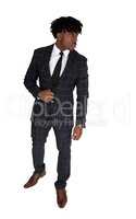 Relaxed black man standing in a suit looking away