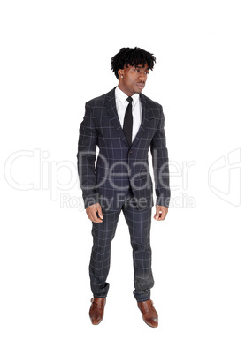 African man in a dark suit standing in the studio with fussy bla
