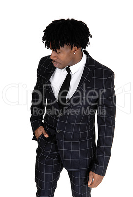 Black man in a dark suit standing in the studio with fussy black