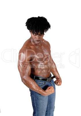 A handsome African man standing topless flexing his muscle