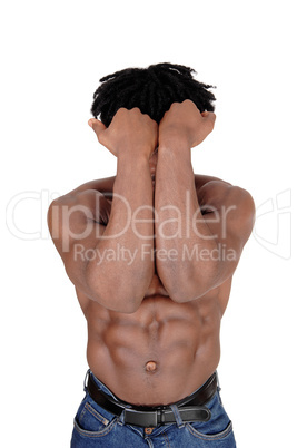 Young African man standing shirtless with his arms over his face