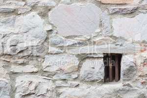 Old Stone Wall With Small Iron Barred Prison Cell Window