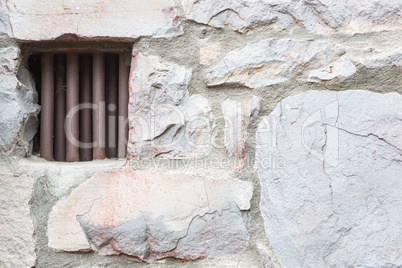 Old Stone Wall With Small Iron Barred Prison Cell Window