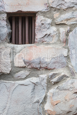 Old Stone Wall With Small Iron Barred Prison Cell Window