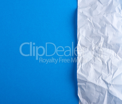 crumpled blank white paper on a blue background