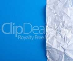 crumpled blank white paper on a blue background