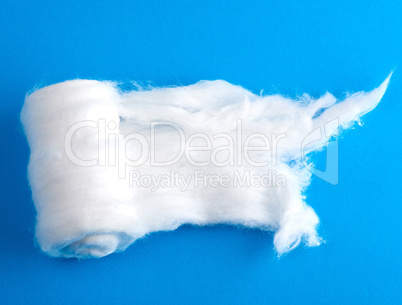 wad of white cotton with torn edges on a blue background