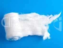 wad of white cotton with torn edges on a blue background