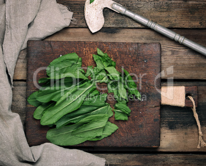 chopped green sorrel leaves on an old brown wooden board