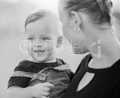 Loving mother with baby girl in arms. Black and white