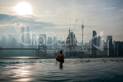 Relaxing in pool and enjoying city panorama. Kuala Lumpur, Malaysia