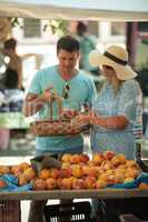 A couple getting peaches at the market