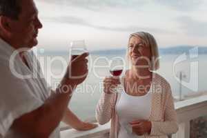 A smiling middle aged couple on a terrace close to the sea