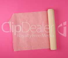 rolled brown parchment paper roll for baking on a white backgrou