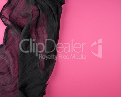 black textile gauze on a pink background
