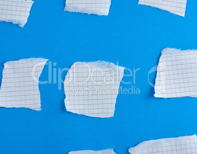 empty torn pieces of white paper on a blue background