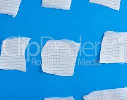 empty torn pieces of white paper on a blue background
