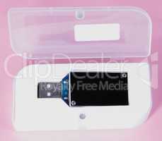 electronic device in plastic case on pink background at day