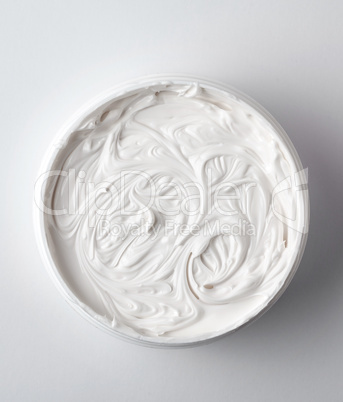 thick white cosmetic cream in a plastic jar