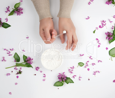 two female hands and a jar with thick cream