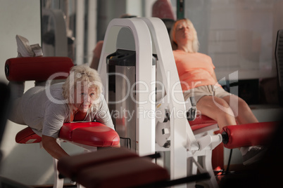 Two middle aged women working out in a gym