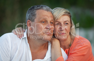 A portrait of a smiling middle aged couple looking into the distance