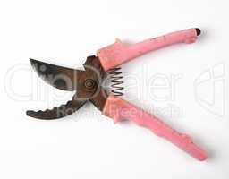 very old pruner with rusty blades, red plastic handles