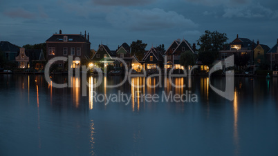 Waterside Dutch village with lights reflection on water at night