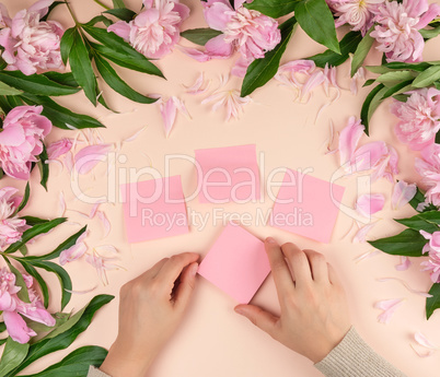 female hands glue empty paper pink stickers on the background wi