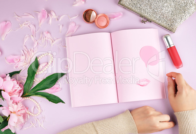 open notebook with blank pink pages, a bouquet of peonies, red l