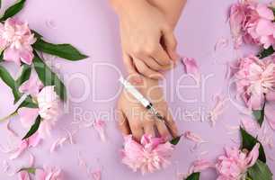 two hands of a young girl with smooth skin and a bouquet of pink