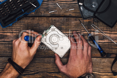 Two Hands with Screwdriver Disassemble HDD