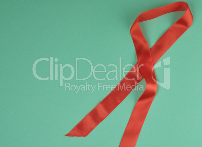red silk ribbon, green background, top view