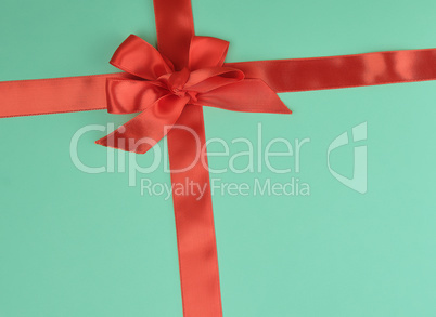 stretched red silk ribbon and tied bow, green background